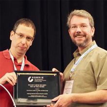 CSE prof. Geoffrey Voelker (right) accepts USENIX Security Test of Time Award on Aug. 16.